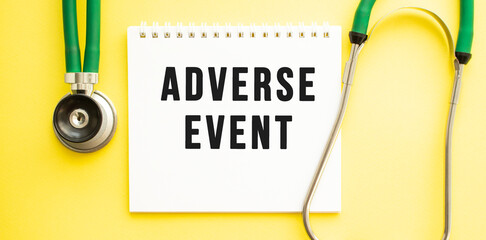 Text ADVERSE EVENT on notebook with stethoscope on yellow background.