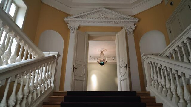 The camera moves up a beautiful staircase at the entrance to a historic building. Cool shots in motion