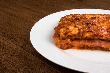 Home made Lasagna in Bolognese sauce, made with ham cheese, tomato sauce and ground beef. Gourmet photo with empty spaces for text.