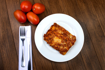 Tasty Lasagna in Bolognese sauce, made with ham cheese, tomato sauce and ground beef. Home made. Top view photography. Italian cuisine.