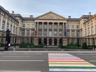 Colourful pride rainbow pedestrian zebra crossing in front of Belgian Federal Parliament building. Belgian government. Bruxelles, Brussels Capital Region, Belgium.