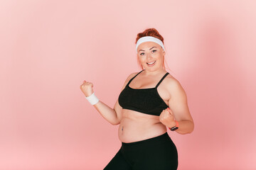 Happy woman with plus size body wearing fitness clothes