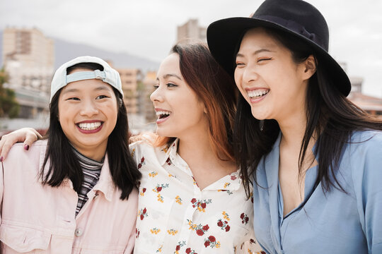 Happy asian girls having fun together outdoor around city - Main focus on center woman face