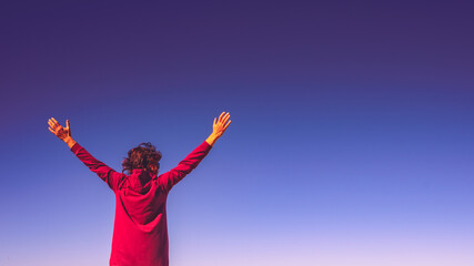 Fototapeta na wymiar Woman with arms up against sky