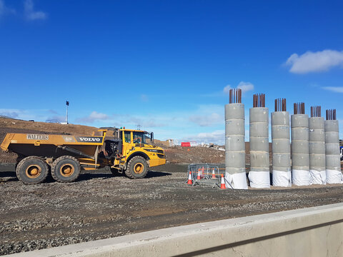 Volvo dumper truck on construction site with reinforced concrete pylons