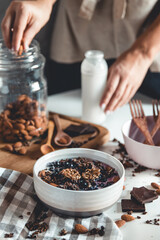 Ideas for an autumn winter breakfast. Spicy yoghurt with granola, dried berries, nuts, almonds, spices (cinnamon, anise), in cup, plate.