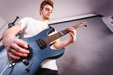 Obraz premium Young man is playing electric guitar