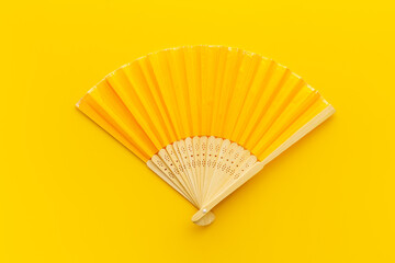 Top view of yellow hand fan made of bamboo and paper