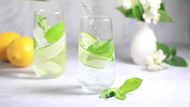 The process of making detox water with cucumber, mint and lemon juice.