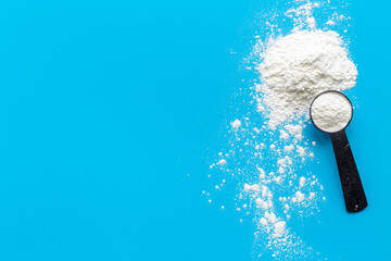 White whey protein powder in scoop. Sport nutrition concept
