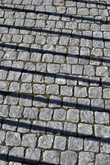 Shadows of Iron Fence Bars on Old Stone  Road 
