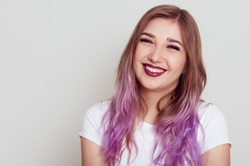 Portrait of smiling happy young female wearing white T-shirt looking at camera with positive...