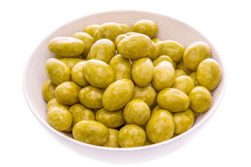 Nuts, almonds in green tea glaze, Matcha in a white plate on a white background. Isolated items and products