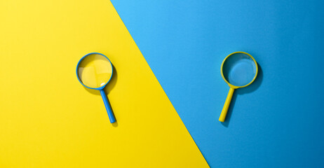 two plastic magnifiers on a yellow-blue background