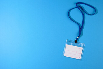 transparent plastic badge on a blue lanyard on a blue background