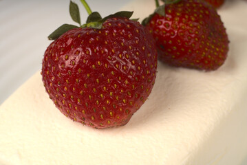 Red juicy strawberries lie on a large ice cream cone.