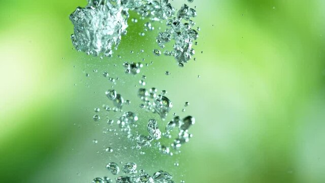 Super Slow Motion Shot of Aloe Vera Cuts Falling into Water on Green Background. Filmed on high speed cinematic camera at 1000fps.