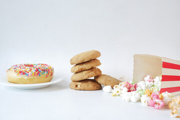 stack of cookies donuts and popcorn on white 
