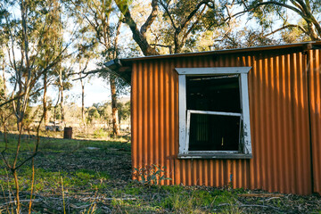 Abandoned orange bush shack nestled in the Australian bush
