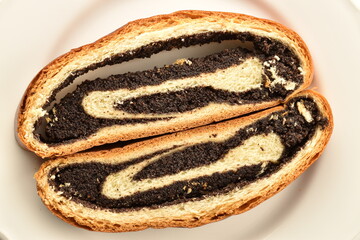 Two slices of delicious sweet poppy seed roll, on a white dish, close-up, top view.