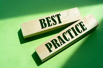 Best practice words in wooden blocks on green. Business or healthcare concept.