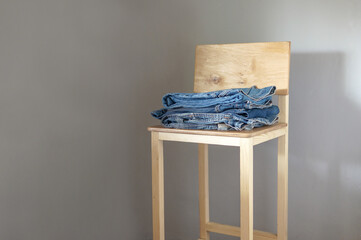 Jeans. Stylish clothes stacked over grey background