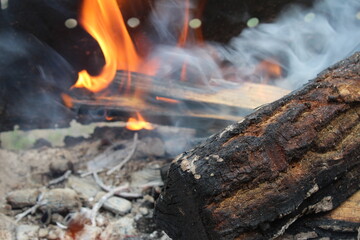bonfire fire with smoke close-up in the dark on a black background. Burning wood, wood