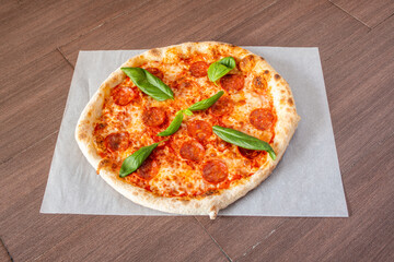 Spicy pepperoni Italian pizza topped with basil leaves