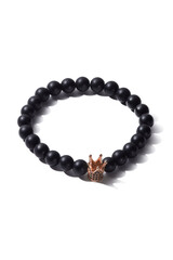 Detail shot of beaded bracelet made of black ornamental stone and decorated with little crown with crystals. Stylish bracelet is isolated on the white background. 