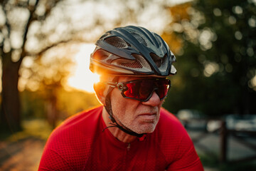 Senior man cycling through forest