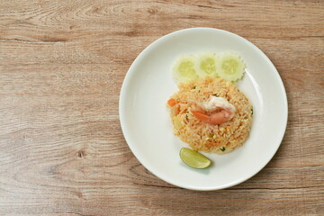 fried rice shrimp and egg with slice cucumber couple lemon on plate