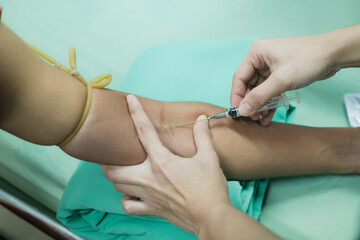 Close up Hand of nurse, doctor or Medical technologist in blue gloves taking blood sample from a patient in the hospital.