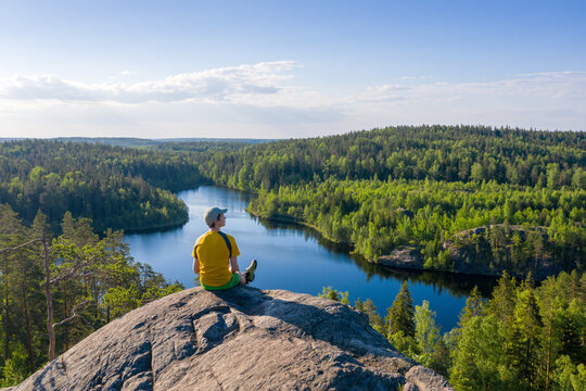 Man sits on the top and contemplates the world of outdoor.