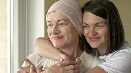 Young woman hugs her sick mom after chemotherapy. Love, care and support in the family of a cancer patient.