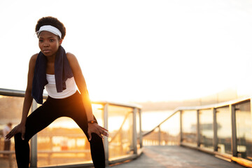 Obraz premium Beautiful girl resting after training outdoors. Young african woman in sportswear.