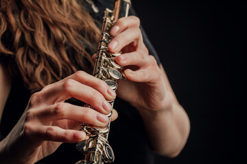 Close-up of the hands of a woman playing the flute. Musical concept.