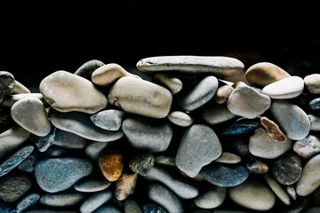 Fototapeta premium Colorful sea pebbles close-up. Background texture, sea stones in the water