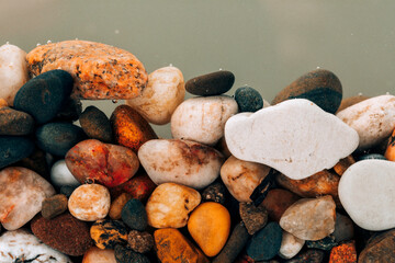 Colorful sea pebbles close-up. Background texture, sea stones in the water