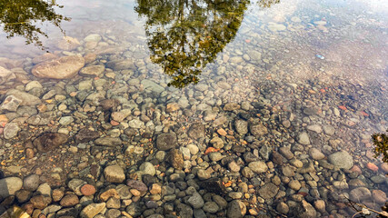 stones in the water with the reflection on water