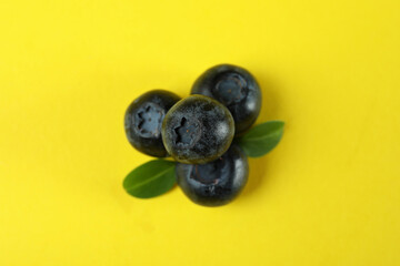 Fresh blueberry with leaves on yellow background