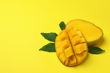 Ripe mango fruit on yellow background, space for text