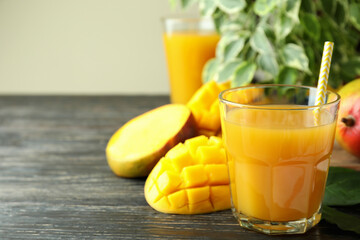 Ripe mango fruit and juice on wooden table