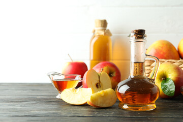 Homemade apple vinegar and ingredients on wooden table