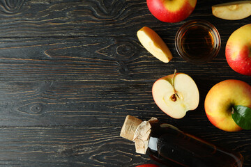 Homemade apple vinegar and ingredients on wooden table