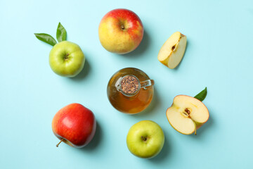 Homemade apple vinegar and ingredients on blue background