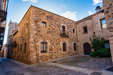 Fototapeta premium Narrow alley with old stone buildings at Caceres, Extremadura, Spain.