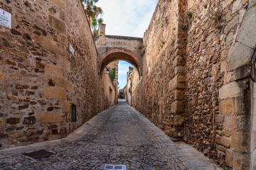 Narrow alley with old stone buildings at Caceres, Extremadura, Spain.