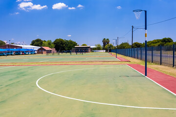 Empty high school netball court against the clear sky