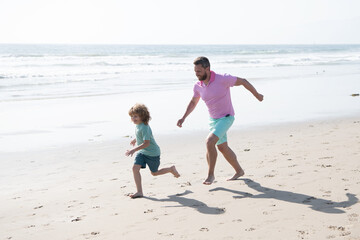 childhood and parenting. father and son running on summer beach. family travel weekend and vacation