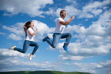 Fototapeta na wymiar father and daughter jump high. hurry up. happy childhood and fatherhood. concept of friendship
